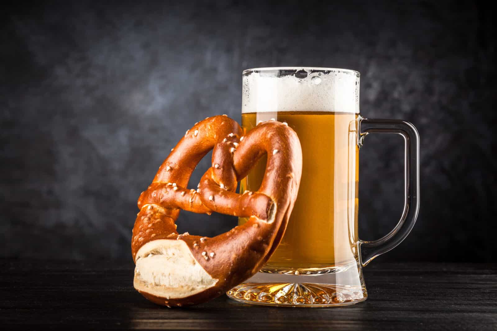 Beer mug and pretzel on dark background